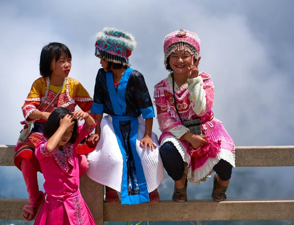 a group of young girls sitting on top of a wooden bench